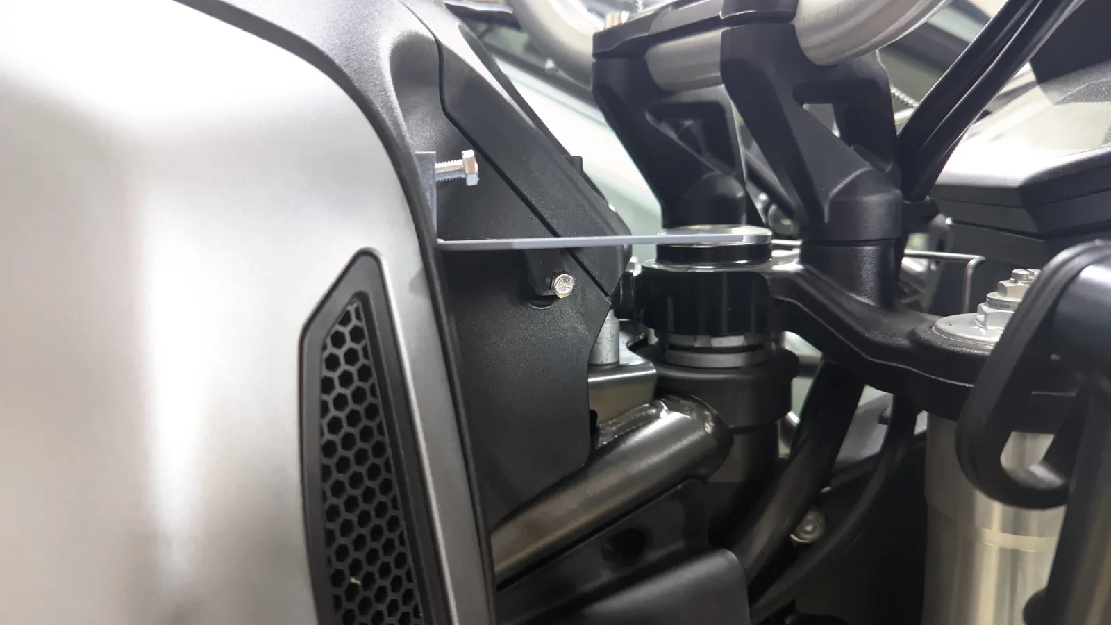 A clear template positioned between the tank and fairing of a Moto Guzzi V85 TT